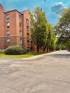 Naperville apartment for rent - A red brick building with a green tree in front.