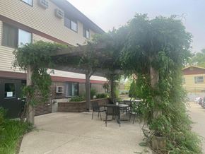 Marion apartment for rent - A patio with a table and chairs under a vine covered pergola.