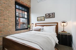 Chicago apartment for rent - a bedroom with a bed and a brick wall