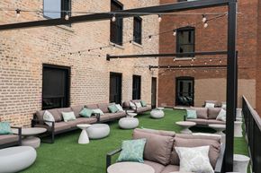 Chicago apartment for rent - a patio with couches and tables in front of a brick building