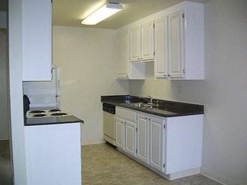 San Jose apartment for rent - a kitchen with white cabinets and a stove and a sink