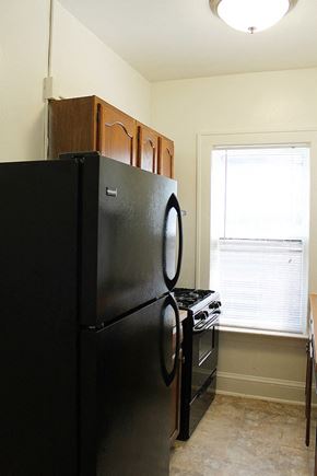 Cleveland Heights apartment for rent - a kitchen with a refrigerator and a stove and a window