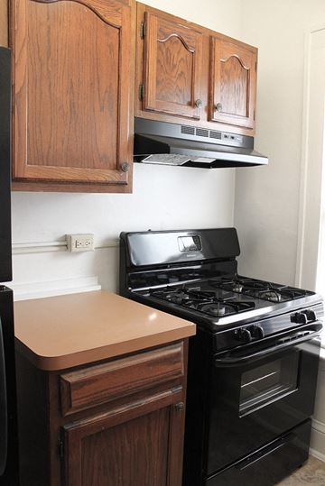 Cleveland Heights apartment for rent - a kitchen with a stove and microwave and wooden cabinets