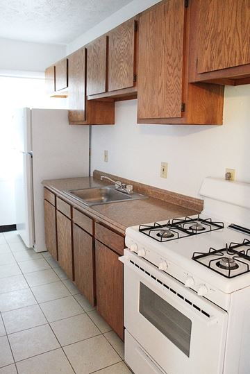 Cleveland Heights apartment for rent - A kitchen with a white stove and wooden cabinets.