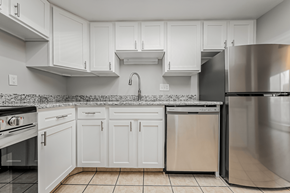 Cleveland apartment for rent - A kitchen with white cabinets and a stainless steel refrigerator.
