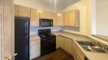 Cuyahoga Falls apartment for rent - a kitchen with black appliances and wooden cabinets
