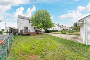 Mayfield Heights house for rent - A white house with a green fence in front of it.