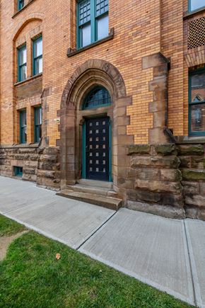 Cleveland apartment for rent - the front of a brick building with a green door and a sidewalk