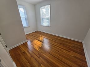 Mentor house for rent - A room with wooden flooring and two windows.