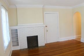 Cleveland Heights apartment for rent - an empty living room with a brick fireplace and wooden floors