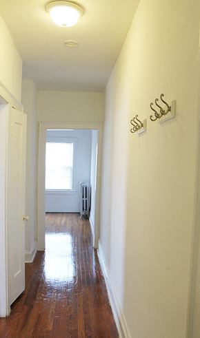 Cleveland Heights apartment for rent - a hallway with white walls and wooden floors and a window