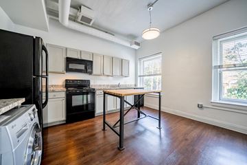 Cleveland apartment for rent - A black fridge is on the left of a kitchen with a black oven and a black microwave.