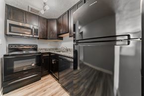 Berea apartment for rent - A kitchen with black cabinets and a stainless steel refrigerator. at Integrity Berea Apartments, Apartments, Berea, OH