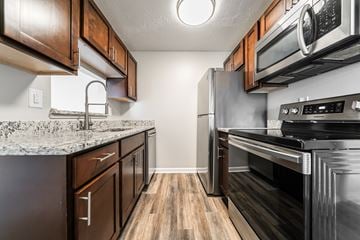 Chardon apartment for rent - A kitchen with dark wood cabinets and stainless steel appliances.