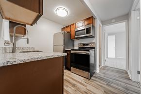 Chardon apartment for rent - A kitchen with a granite countertop and wooden cabinets at Integrity Chardon Apartments,Ohio, 44024