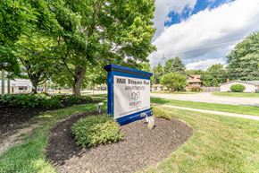 Berea apartment for rent - A sign for Mill Stream Run Apartments is shown in front of a tree.