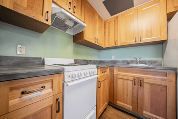 Berea apartment for rent - A kitchen with a white stove and wooden cabinets.