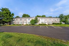 Olmsted Falls apartment for rent - A large building with a parking lot in front of it.