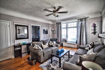 Cleveland apartment for rent - a living room with a gray couch and a ceiling fan