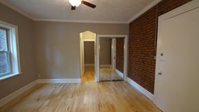 Cleveland Heights apartment for rent - an empty living room with wood floors and a brick wall