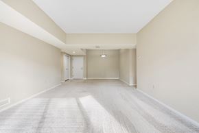Beachwood apartment for rent - A spacious living room with a carpeted floor and white walls.at Atrium in The Village, Ohio