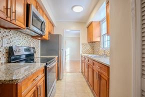 Cleveland apartment for rent - A kitchen with wooden cabinets and a tile backsplash Integrity Realty, Cleveland, OH