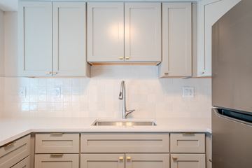 Beachwood apartment for rent - A kitchen with white cabinets and a stainless steel refrigerator.