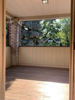 Cleveland Heights apartment for rent - A sunny day in a wooden deck with a view of a green house and trees.