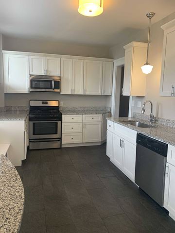 Cleveland Heights apartment for rent - a large kitchen with white cabinets and stainless steel appliances