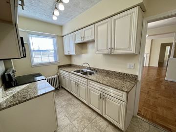 Cleveland apartment for rent - A kitchen with white cabinets and a granite countertop.