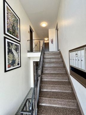 Woodmere apartment for rent - a stairway with a metal railing and pictures on the wall