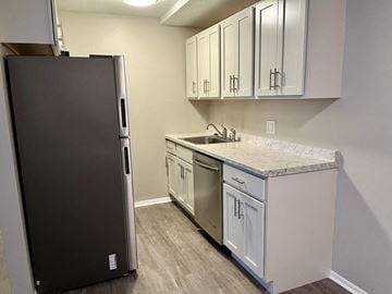 Chardon apartment for rent - a kitchen with white cabinets and a stainless steel refrigerator