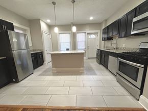 Cleveland Heights apartment for rent - A kitchen with black appliances and white tiled floors at Integrity Cleveland Heights Apartments, Apartments, Cleveland Heights, OH