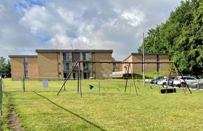 Northfield apartment for rent - a swing set in front of an apartment building