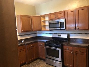 Cleveland Heights apartment for rent - a kitchen with a stove and a microwave and wooden cabinets