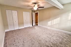Cleveland apartment for rent - an empty living room with carpet and a ceiling fan