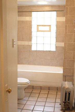 Cleveland Heights apartment for rent - A white toilet sits next to a bathtub in a bathroom.