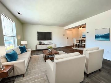 Brunswick apartment for rent - a living room with white couches and chairs and a television