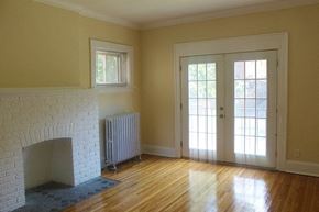Cleveland Heights apartment for rent - a living room with a white brick fireplace and a door