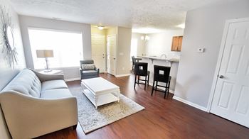 Living room with a couch and a table in front of a kitchen