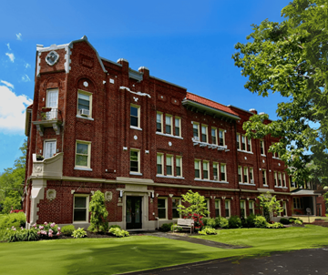 Lakewood apartment for rent - A red brick building with a green lawn in front.