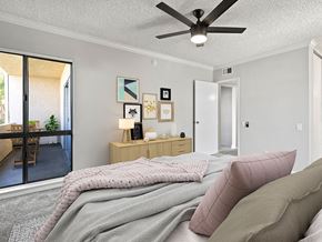 Sherman Oaks apartment for rent - Carpeted bedroom with ceiling fan and natural light from adjacent patio.