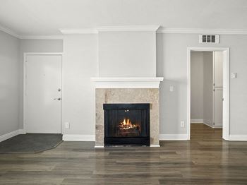 Tiled fireplace in hardwood floored living room.