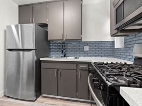 Sylmar apartment for rent - Blue tiled kitchen with stainless steel fridge, oven, and microwave.