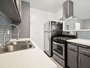 North Hollywood apartment for rent - Blue tiled kitchen with stainless steel fridge, oven, and fixtures.