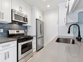 Valley Glen apartment for rent - Blue tiled kitchen with quartz stone counters and stainless steel microwave, oven, fridge, and fixtures.