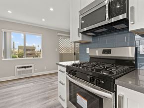 Los Angeles apartment for rent - Blue tiled kitchen with stainless steel oven, microwave, and fridge.