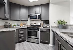 Encino apartment for rent - Stone tiled kitchen with stainless steel oven, microwave, and fixtures.