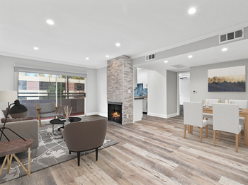 Hardwood floored living room with stone walled fireplace.
