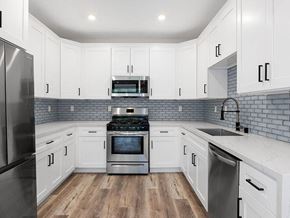 Los Angeles apartment for rent - White tiled kitchen with stainless steel fridge, over, microwave, and fixtures.